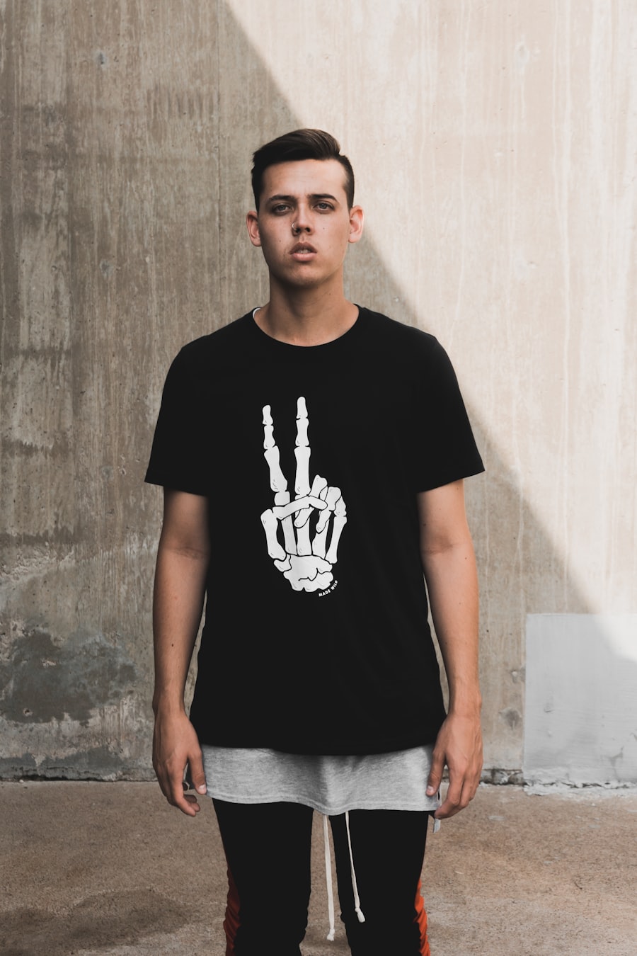 The sample full-body photo before any try-on: a person in a black t-shirt against a concrete wall.